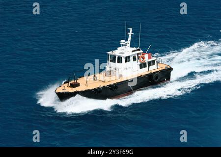 Nassau, Bahamas - 15 avril 2008 : un bateau-pilote navigue dans les eaux près du port de croisière de Nassau Banque D'Images