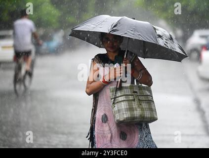 Noida, Inde. 13 septembre 2024. NOIDA, INDE - 13 SEPTEMBRE : les navetteurs sortent sous la pluie soudaine de l'après-midi, le 13 septembre 2024 à Noida, Inde. Le département météorologique indien (IMD) a émis une alerte « orange », indiquant un mode « soyez prêt », car des conditions météorologiques extrêmement mauvaises sont prévues. (Photo de Sunil Ghosh/Hindustan Times/Sipa USA ) crédit : Sipa USA/Alamy Live News Banque D'Images