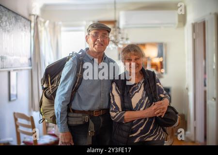 Heureux couple senior actif debout à la maison, prêt pour les voyages de vacances Banque D'Images