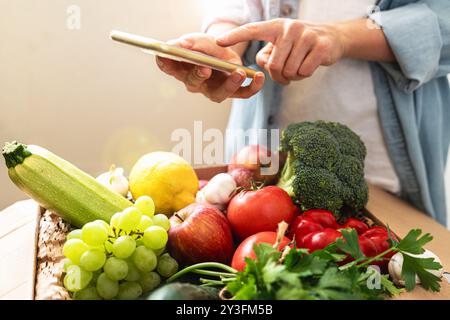 Commande en ligne de légumes et de fruits cultivés à la ferme à l'aide d'un téléphone mobile et d'une application mobile. Shopping à domicile d'aliments sains. Banque D'Images