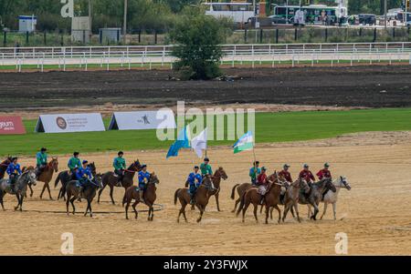 Les cavaliers kazakhs et ouzbeks au kokpar (kok boru), une compétition sportive asiatique traditionnelle, pendant les Jeux mondiaux nomades, Astana, Kazakhstan. Banque D'Images