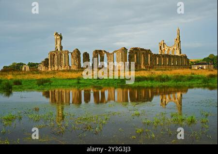 Abbaye de Byland dans le Yorkshire du Nord. Les ruines de l'abbaye se reflètent dans les champs gorgés d'eau Banque D'Images