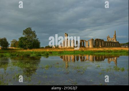 Abbaye de Byland dans le Yorkshire du Nord. Les ruines de l'abbaye se reflètent dans les champs gorgés d'eau Banque D'Images