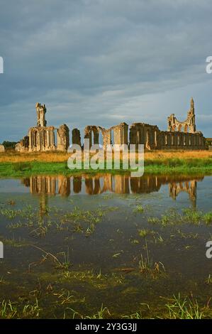 Abbaye de Byland dans le Yorkshire du Nord. Les ruines de l'abbaye se reflètent dans les champs gorgés d'eau Banque D'Images