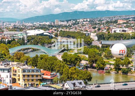 Tbilissi, Géorgie - 12 août 2024 : le Pont de la paix est un pont piétonnier en forme d'arc, une construction en acier et en verre au-dessus de la rivière Kura, reliant th Banque D'Images