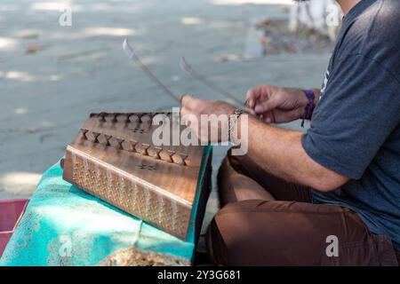 Tbilissi, Géorgie - 14 août 2024 : jeune musicien iranien jouant du santur, un instrument de musique persan traditionnel et chantant dans la rue à Tbilissi. Banque D'Images