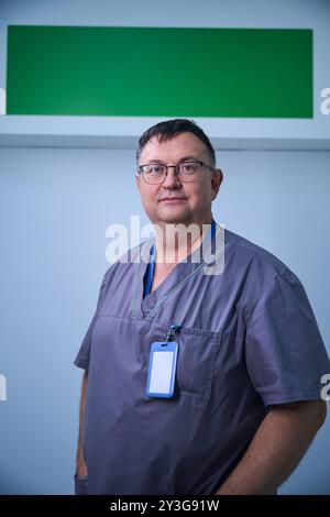 Médecin debout avec confiance dans le couloir de la clinique Banque D'Images