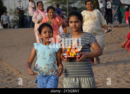 Mumbai, Inde. 13 septembre 2024. Les dévots portent des idoles du Dieu hindou à tête d'éléphant Ganesh pour une immersion sur une plage. Les dévots prient le Dieu hindou à tête d'éléphant Ganesh qui est considéré comme le Dieu de la sagesse, de la prospérité et de l'élimination des obstacles avant de lui dire au revoir et d'immerger l'idole dans les plans d'eau qui coulent librement comme le lac, la rivière ou la mer. (Photo par Ashish Vaishnav/SOPA images/SIPA USA) crédit : SIPA USA/Alamy Live News Banque D'Images