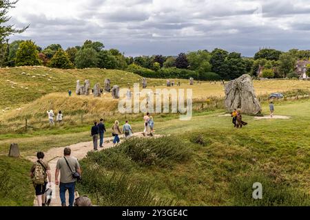 Avebury, Royaume-Uni- 25 août 2024 : gens marchant près de standing Stones dans le cercle préhistorique d'Avebury Stone, Wiltshire, Angleterre, Royaume-Uni. Banque D'Images