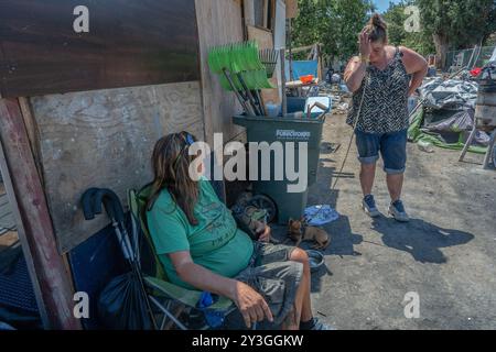 Sacramento, CA. 31 juillet 2024. Après avoir reçu une notification de la ville de Sacramento pour quitter la digue de Morrison Creek la semaine dernière Kristin Florez, 43 ans, et son chien, petite fille, et Robin Aiello, 58, à gauche, qui est handicapé et a trois chiens de compagnie, a déménagé à la 63e rue où ils pensaient qu'ils seraient en sécurité jusqu'à ce qu'ils soient balayés le mercredi 31 juillet 2024. « C'est stressant, très fatiguant et ça tue notre âme et notre corps, ça le fait vraiment », a dit Florez. Florez a dit qu'elle souhaitait que la ville puisse l'aider, elle a dit qu'elle avait l'habitude de travailler et d'aller à l'école, mais qu'elle ne pouvait pas maintenir ni l'un ni l'autre sans-abri. Th Banque D'Images