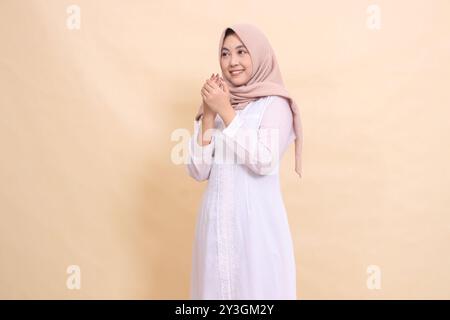 Femme belle indonésie portant une robe blanche hijab se tient franchement souriant demandant Dieu. pour la religion Banque D'Images