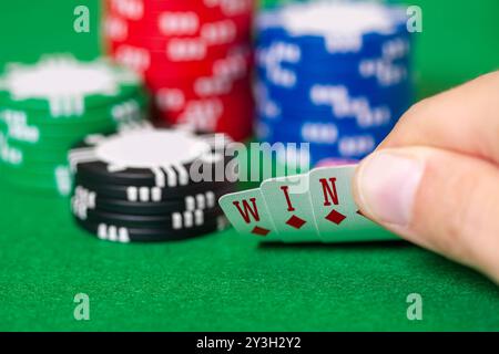 Les doigts détiennent des cartes qui sortent GAGNANTES, avec des jetons, des jeux d'argent, du poker, du blackjack ou du Texas Hold 'em à Las Vegas ou au casino Banque D'Images