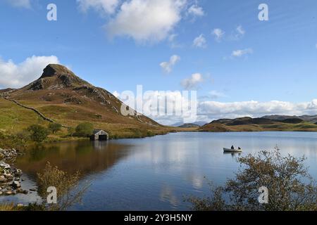 Personnes pêchant sur un bateau sur le lac Cregennan, parc national de Snowdonia - Nord du pays de Galles, Royaume-Uni - 13 septembre 2024 Banque D'Images