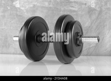 Sport et fitness - haltère noir avec quatre poids de fond en béton Banque D'Images