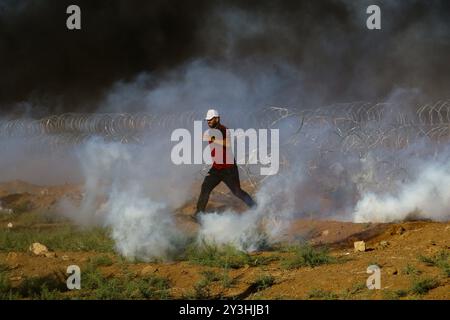 Palestiniens victimes des affrontements à Gaza près de la frontière Gaza-Israël Un certain nombre de Palestiniens sont blessés par des gaz lacrymogènes et des balles réelles tirées sur eux par des soldats israéliens lors d'affrontements à l'est de la ville de Gaza, près de la frontière Gaza-Israël et de l'avant-poste israélien de Nahal Oz. Les Palestiniens ont brûlé des pneus et lancé des pierres sur les soldats israéliens de l'autre côté de la clôture pendant les affrontements. Ils ont manifesté dans plusieurs endroits dans l’est de la bande de Gaza, près de la frontière Gaza-Israël pour le 18ème vendredi consécutif depuis que la manifestation de la Grande Marche du retour a commencé au e Banque D'Images