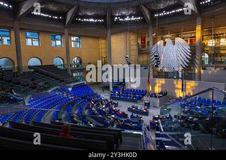 Deutscher Bundestag Plenarsaal. Deutschland, Berlin AM 12.09.2024 : Plenarsaal mit seitlichem Blick auf den Bundesadler, Warmes Licht der Abendsonne erhellt den Hintergrund. *** Bundestag allemand salle plénière Allemagne, Berlin le 12 09 2024 salle plénière avec vue latérale de l'aigle fédéral, la lumière chaude du soleil du soir illumine le fond Banque D'Images