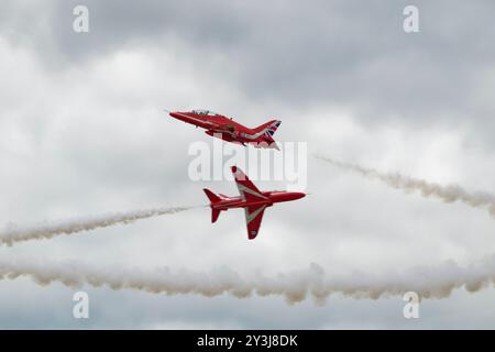 Dans leur 60e année d'exploitation, deux Hawker Siddeley Hawk Jet Trainers de l'équipe britannique de voltige Red Arrows effectuent un cross over Banque D'Images