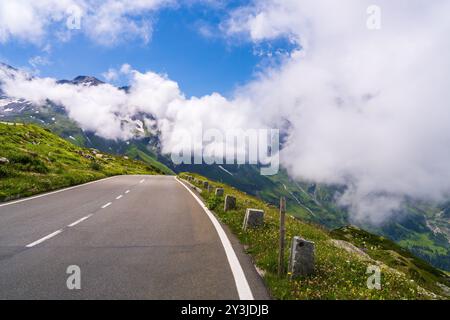 Célèbre route de montagne, serpentine Grossglockner-Hochalpenstrasse dans les vents le long des pentes de montagne escarpées pittoresques. D'énormes montagnes sont cachées dans c Banque D'Images