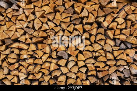 Souches de bois, bois de chauffage empilés en piles. Bûches fendues empilées. Pile de bûches préparées pour l'hiver. Photo de haute qualité. Arrière-plan, arrière-plan photo Banque D'Images