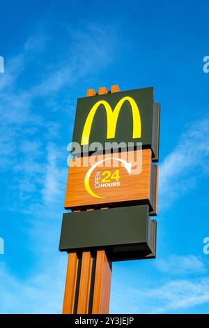 Panneau McDonald's ouvert 24 heures isolé contre le ciel bleu Banque D'Images