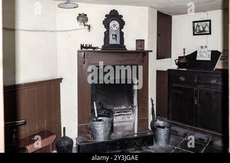 Cultra County Down Northern Ireland septembre 2024 - Vieux feu ouvert avec un entourage en bois et une horloge de manteau et des seaux de charbon sur le sol Banque D'Images