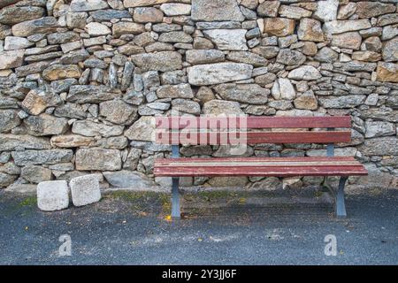 Banc en bois contre le mur en pierre. Banque D'Images