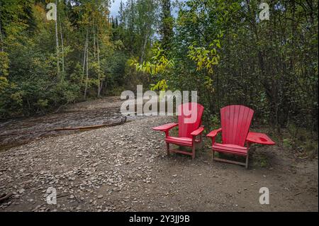 Vue automnale du ruisseau Bonanza et des chaises rouges sur le site de la découverte originale d'or du Klondike dans le territoire du Yukon Banque D'Images