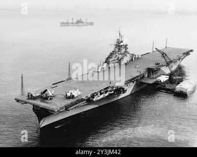 Le porte-avions USS bon homme Richard (CV-31) de l'US Navy ancre dans le port de New York (États-Unis), avec des barges de ravitaillement à côté, le 9 janvier 1945. Photographié depuis une base aérienne navale de New York, avion, volant à une altitude de 90 mètres Banque D'Images