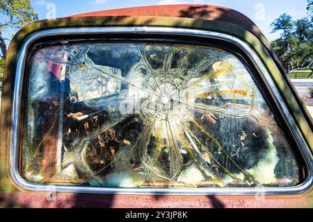 Fenêtre fissurée sur une vieille voiture ancienne junkyard Banque D'Images