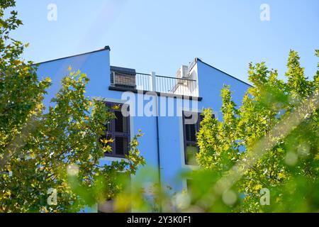 Koper, Slovénie - 25 août 2024 : un bâtiment résidentiel bleu moderne entouré d'arbres verts *** Ein modernes blaues Wohngebäude, umgeben von grünen Bäumen Banque D'Images