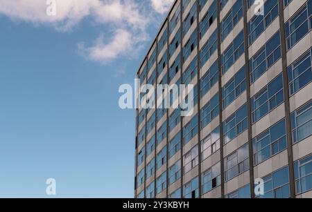 Façade d'immeuble de bureaux avec de nombreuses fenêtres et le ciel bleu par une journée ensoleillée Banque D'Images