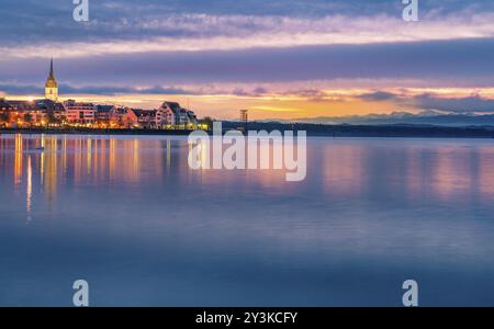 Paysage enchanteur avec un ciel coloré reflété dans l'eau du lac Bodensee, comme le soleil se lève, sur la ville de Friedrichshafen, Allemagne, EUR Banque D'Images