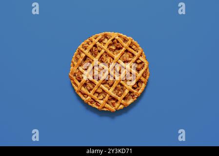 Vue de dessus avec une tarte aux pommes maison isolée sur un fond bleu. Gâteau en croûte grillagée fraîchement cuit au four avec garniture aux pommes Banque D'Images
