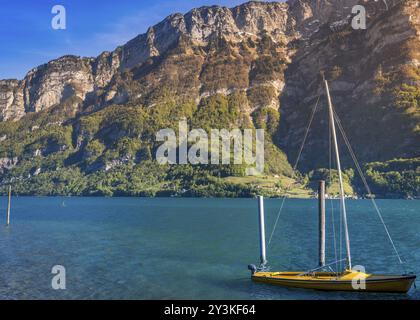 Image prise dans l'Ost de Murg, village suisse, présentant un petit bateau sur le lac de Walenstadt dans la lumière du soleil du matin, entouré par les Alpes Suisses m Banque D'Images