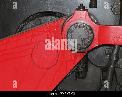 Détails de la roue de locomotive à vapeur noire avec entraînement rouge et bielles avec boulons et fuite d'huile Banque D'Images