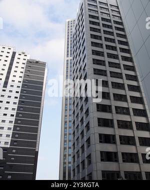 Gros plan d'une rangée de grands immeubles modernes avec revêtement blanc géométrique et fenêtres sombres Banque D'Images