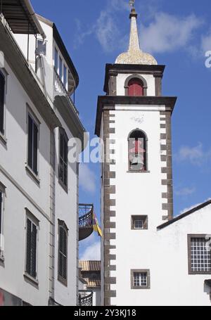 Une rue de vieilles maisons peintes en blanc et la tour de l'église paroissiale historique de saint peters à funchal madère Banque D'Images