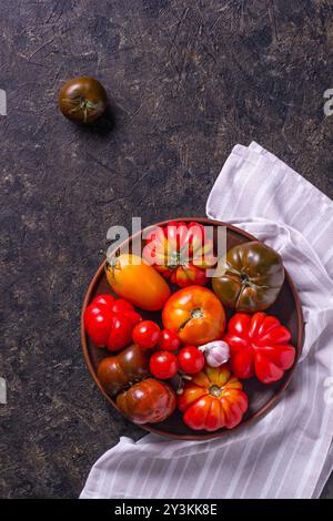 La récolte de tomates assorties.Tomates biologiques colorées sur un grand plat.Tomates différentes variétés.Vue de dessus Banque D'Images