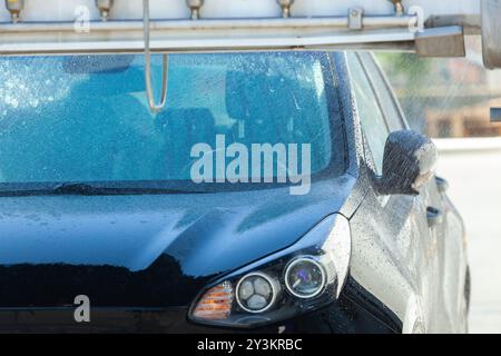 Black car est nettoyé par un système de lavage automatique Banque D'Images