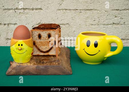 smiley oeuf tasse à café tasse porte-pain table de petit déjeuner Banque D'Images