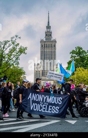 Les membres du groupe d'activistes Anonymous for the Voiceless tiennent une bannière alors qu'ils défilent devant un monument central de Varsovie. Des militants et des défenseurs des droits des animaux défilent dans les rues de Varsovie pour sensibiliser à la souffrance terrible des animaux pris au piège dans les usines et l'agriculture industrielle. La marche est présentée comme une occasion pour la communauté de s'unir et de faire entendre leur voix, scandant sur l'importance de l'égalité pour les animaux. Les participants ont commencé leur action à la statue de Copernic sur la rue Nowy Swiat. Ils ont marché avec des banderoles et des pancartes vers le bas à travers le centre-ville, Behin Banque D'Images