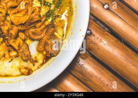 Bol de porridge de poulet servi avec des plats uniques. Porridge de poulet traditionnel avec des plats satay d'intestin de poulet, authentique traditionnel d'Indonésie Banque D'Images