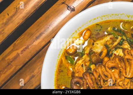 Bol de porridge de poulet servi avec des plats uniques. Porridge de poulet traditionnel avec des plats satay d'intestin de poulet, authentique traditionnel d'Indonésie Banque D'Images