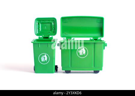Deux poubelles miniatures vertes isolées sur un fond blanc propre. Concept de recyclage et de gestion des déchets. Banque D'Images