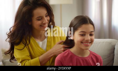 Bienveillant amour caucasien mère femme femme soeur tressant cheveux faire coiffure coiffure souriante petite fille enfant fille fille frère frère parler Banque D'Images