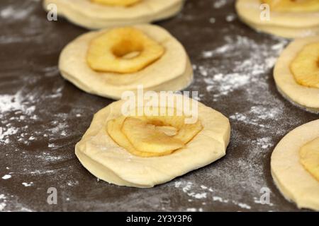 La pomme sonne sur une planche avant la cuisson Banque D'Images