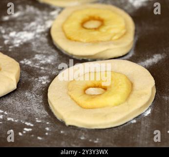 La pomme sonne sur une planche avant la cuisson Banque D'Images