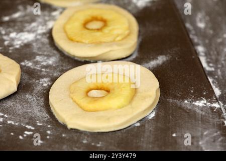 La pomme sonne sur une planche avant la cuisson Banque D'Images
