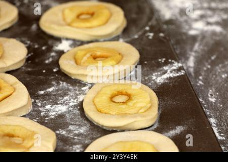 La pomme sonne sur une planche avant la cuisson Banque D'Images