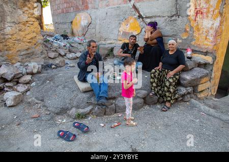 Ankara, Turquie - 13 juin 2022 : personnages colorés contre la façade en ruine : cinq personnages assis et debout, représentant différents âges et styles. Banque D'Images